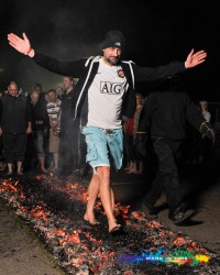 Firewalk charity event in aid of the peace hospice man in shorts walking on fire mark in time event photography